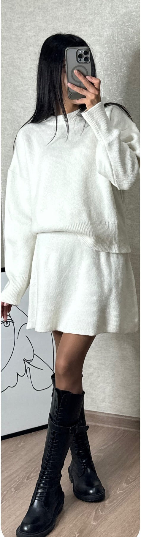Kobieta w dzianinowym komplecie sweter i spódnica mini